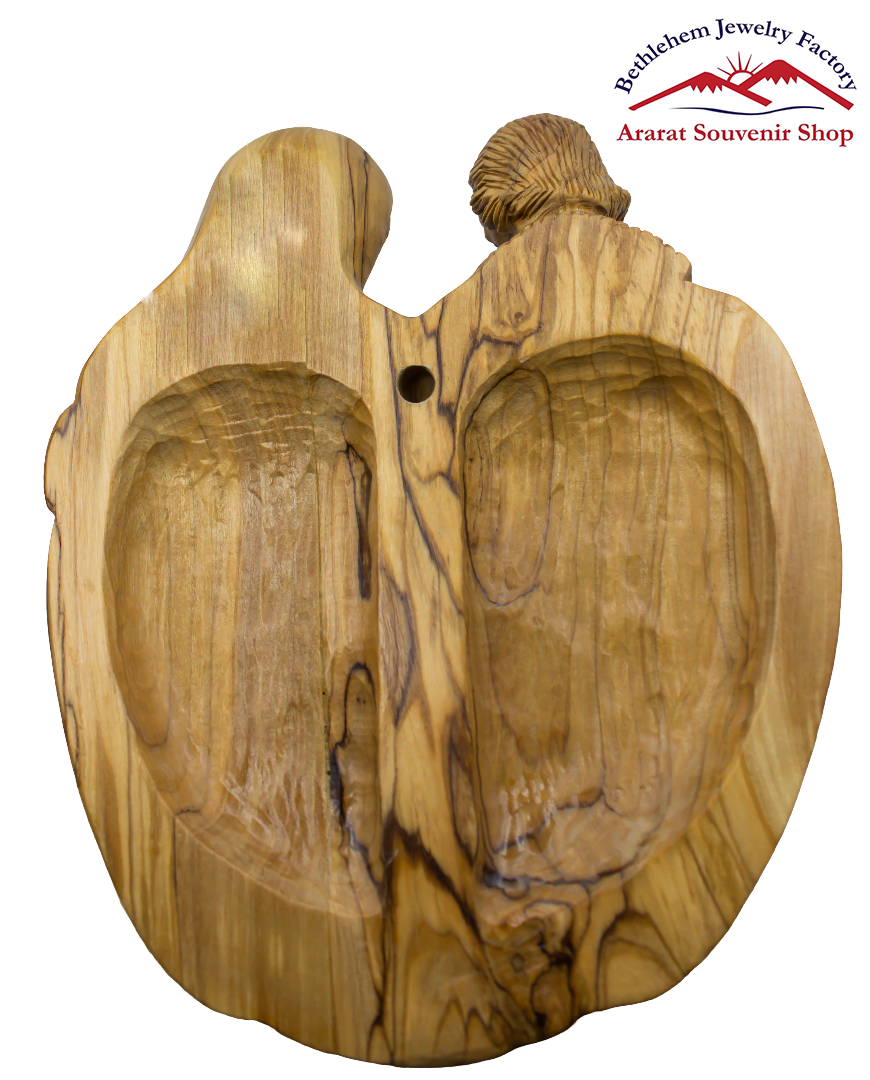 A wooden carving of The Holy Family in the shape of a heart, representing the Holy Family.